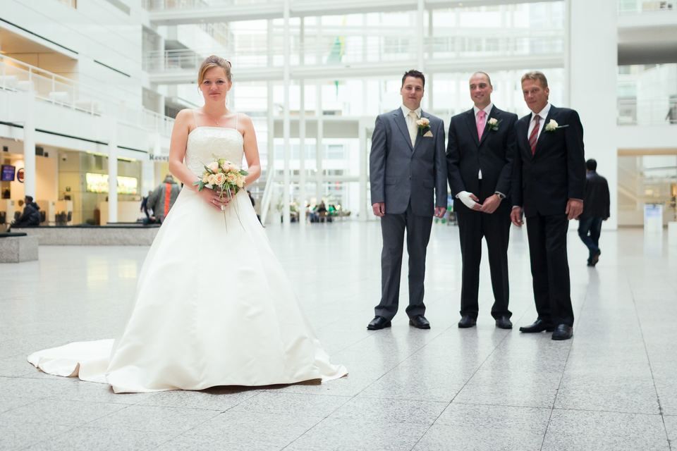 Bruid in trouwjurk voor het altaar met drie bruidegoms