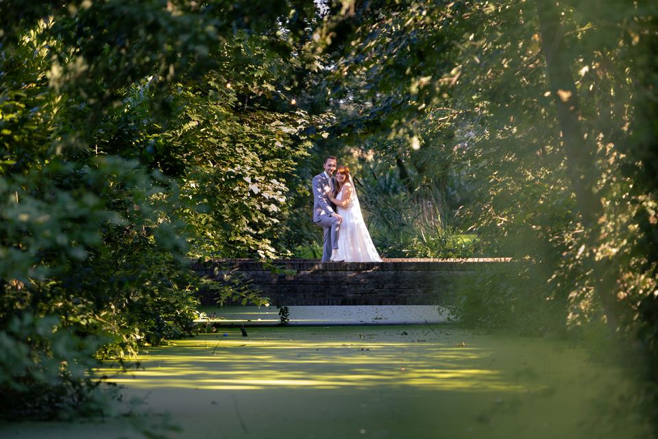 Bruidspaar liefdevol moment in groene waterpark omgeving