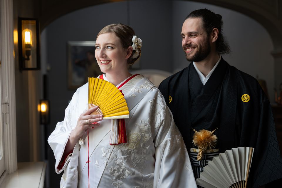 Gelukkig bruidspaar in japanse bruiloftkledij met waaiers